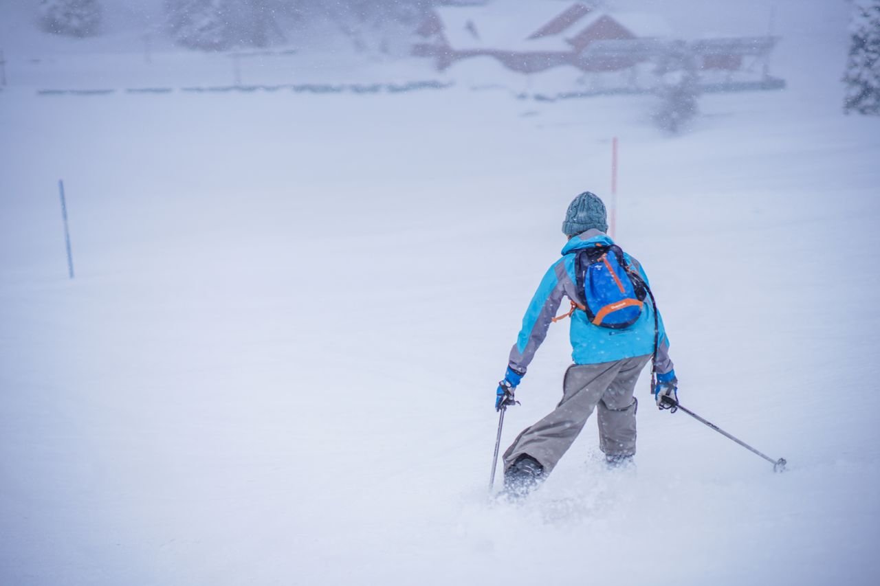 Crafting Captivating Headlines: Your awesome post title goes here Back view of a man skiing on a snow-covered slope in winter.