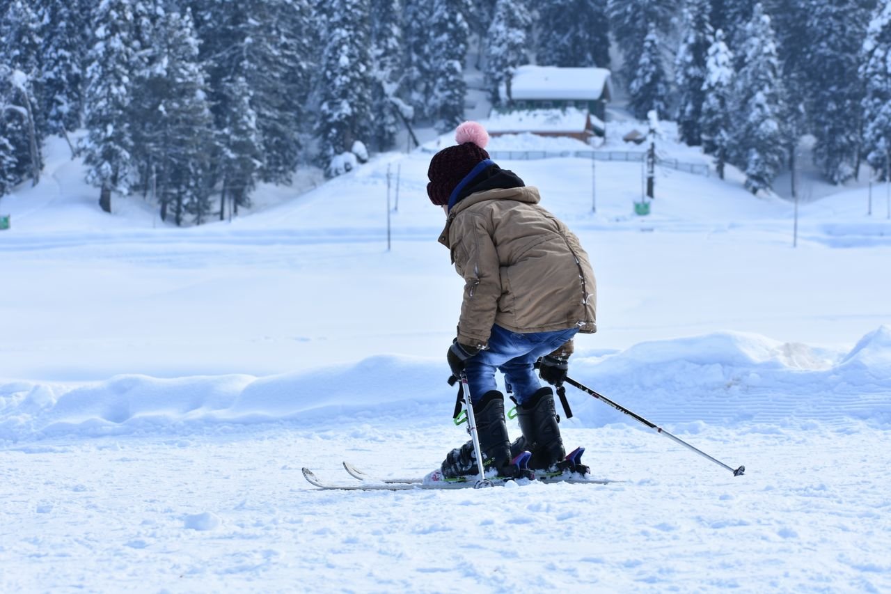 services-01 A child in a brown jacket skiing in a snowy landscape, capturing the essence of winter sports fun.